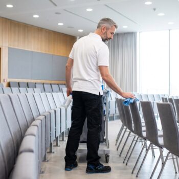 Eventreinigung Düsseldorf: FERMA wischt die Stuhlreihen in einem modernen Kongresssaal ab